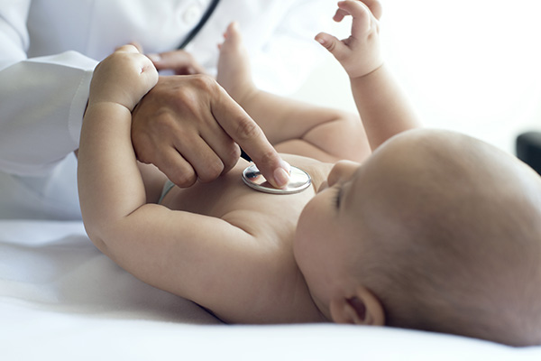 Baby plays with hand of pediatrician, horizontal