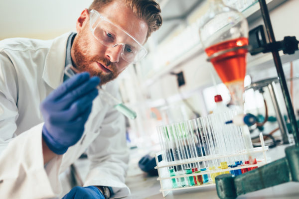 Attractive male student of chemistry working in laboratory